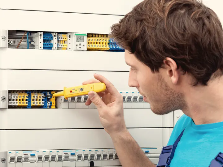 Électricien vérifiant un panneau de disjoncteurs